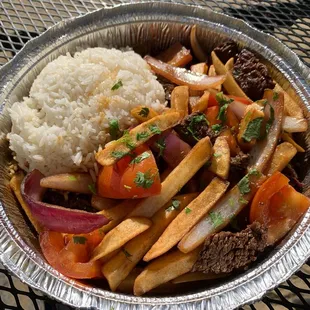 Lomo saltado. Rice is not fully cooked..