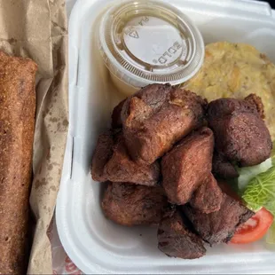 a tray of food with meat, bread, and salad