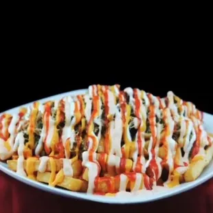 TriPapas: Fries topped with beef, roast pork, chicken, cheese, sour cream, ketchup, mayo-ketchup, lettuce, tomato, potato sticks