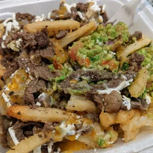 Carne Asada Fries. French fries topped with carne asada, guacamole, sour cream, and cheese. Large size pictured, $10.