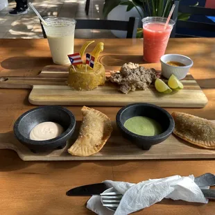 Mofongo Beefsteak , smoothies Mango and strawberry  . chicken and beef empanadas with green and pink sauce .