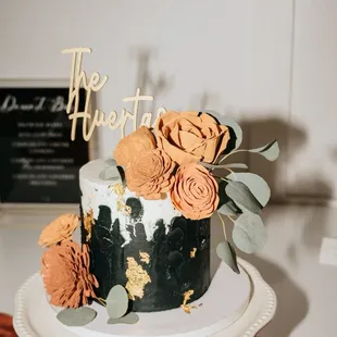 a black and white cake with orange flowers
