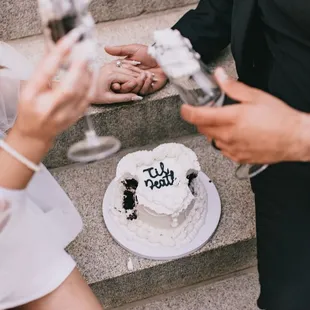 a bride and groom toasting their wedding cake