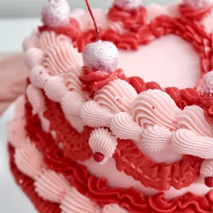 a heart shaped cake with cherries on top