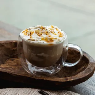 a cup of coffee on a wooden tray