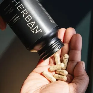 a hand holding a bottle of herban