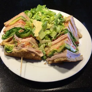 Turkey club with avocado and salad.