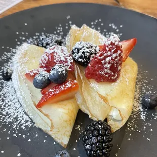 a crepe with berries and powdered sugar