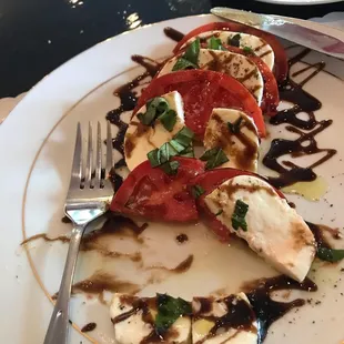 Capressi salad with flavorful fresh tomatoes, creamy mozzarella and fragrant basil and balsamic glaze