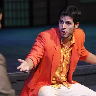 a man in an orange jacket sitting on a bench