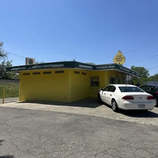 a car parked in front of a yellow building