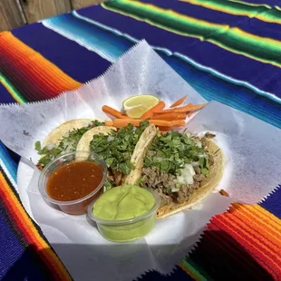 Taco de carnitas, taco de chorizo, y taco de asada
