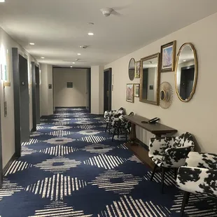 a hallway with chairs and mirrors