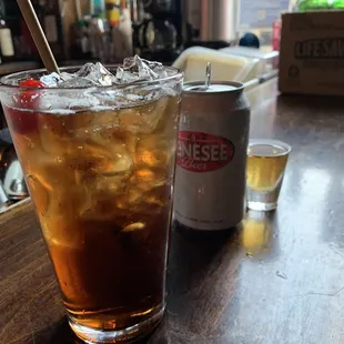 a glass of iced tea and a can of soda