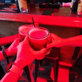 two people clinking glasses with drinks