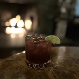 a cocktail with a lime slice on the rim
