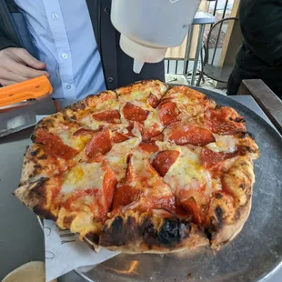 Watching them put hot honey on our pizza.