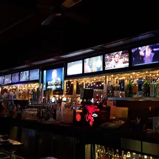 a bar with multiple televisions on the wall