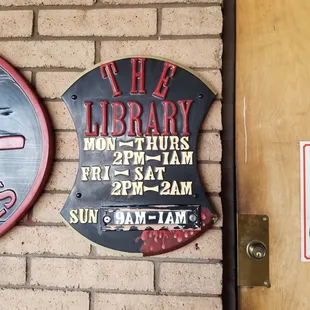 a clock and a sign on a brick wall