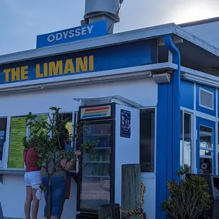 two people standing outside of a restaurant