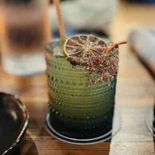 a glass with a drink and a spoon