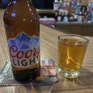 a glass of beer and a bottle of coors light