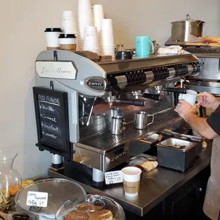 a man standing in front of a coffee machine
