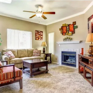 Living area with ceiling fan and fireplace