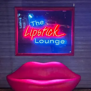 a pink couch and neon sign