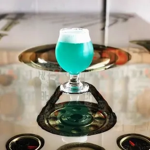 a blue drink in a glass