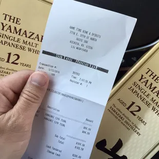 a hand holding a receipt