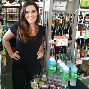 a woman standing in front of a display of liquor