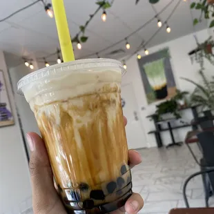 a hand holding a cup of iced coffee
