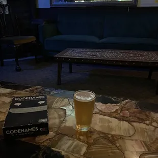 a glass of beer and a book on a table