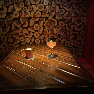 a wooden table with two cups of coffee on it