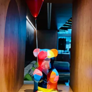 a colorful bear holding a balloon