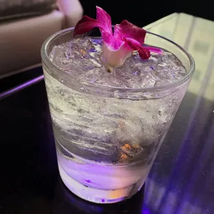 a glass of water with a flower in it
