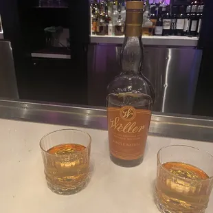 a bottle of whiskey and two glasses