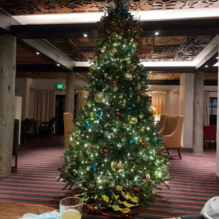 a decorated christmas tree and a glass of orange juice