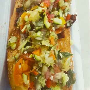 a hot dog with vegetables