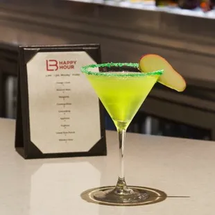 a green cocktail in a martini glass