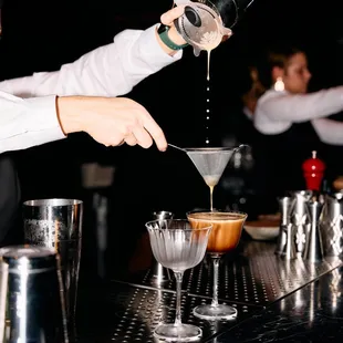 a bartender pouring a martini