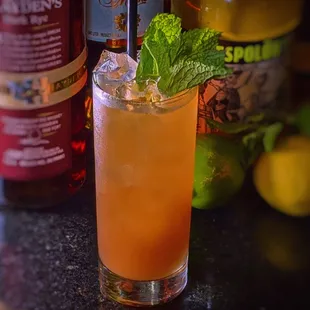 a cocktail with a mint leaf garnish
