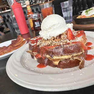 a plate of french toast with strawberries and whipped cream