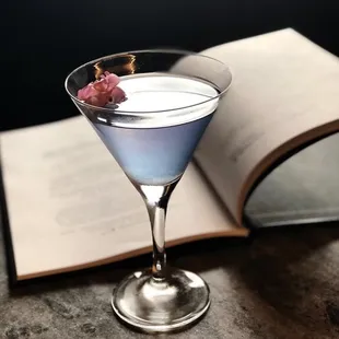 a blue cocktail in a martini glass