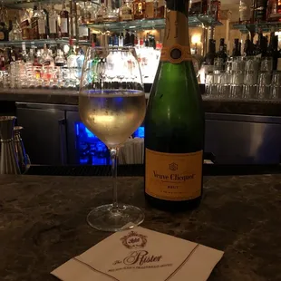 a bottle of champagne and a glass of wine