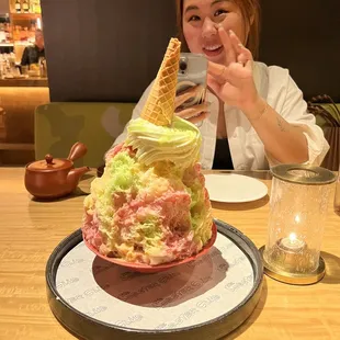 a woman sitting at a table with an ice cream cone