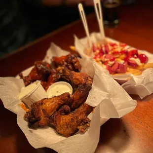 two baskets of chicken wings and fries