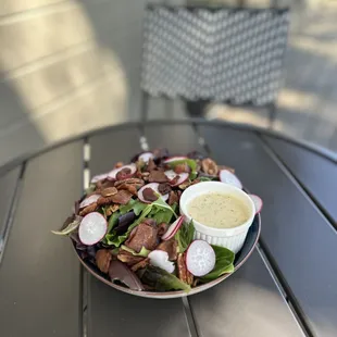 The Local Salad- Organic spring mix, savory bacon, thin sliced radish, maple candied pecans and TLC's house made herb vinaigrette dressing.