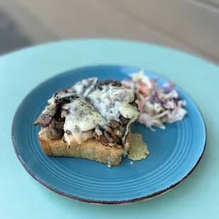 Mushroom Toast- Mushrooms sautéed in white wine and herbs piled on toasted Levain bread and topped with melted Gruyère cheese